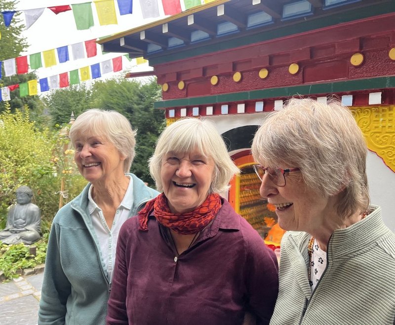 Drei Frauen vor einem bunten Schrein